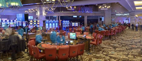 Un casino con varias mesas de juego y máquinas tragamonedas.