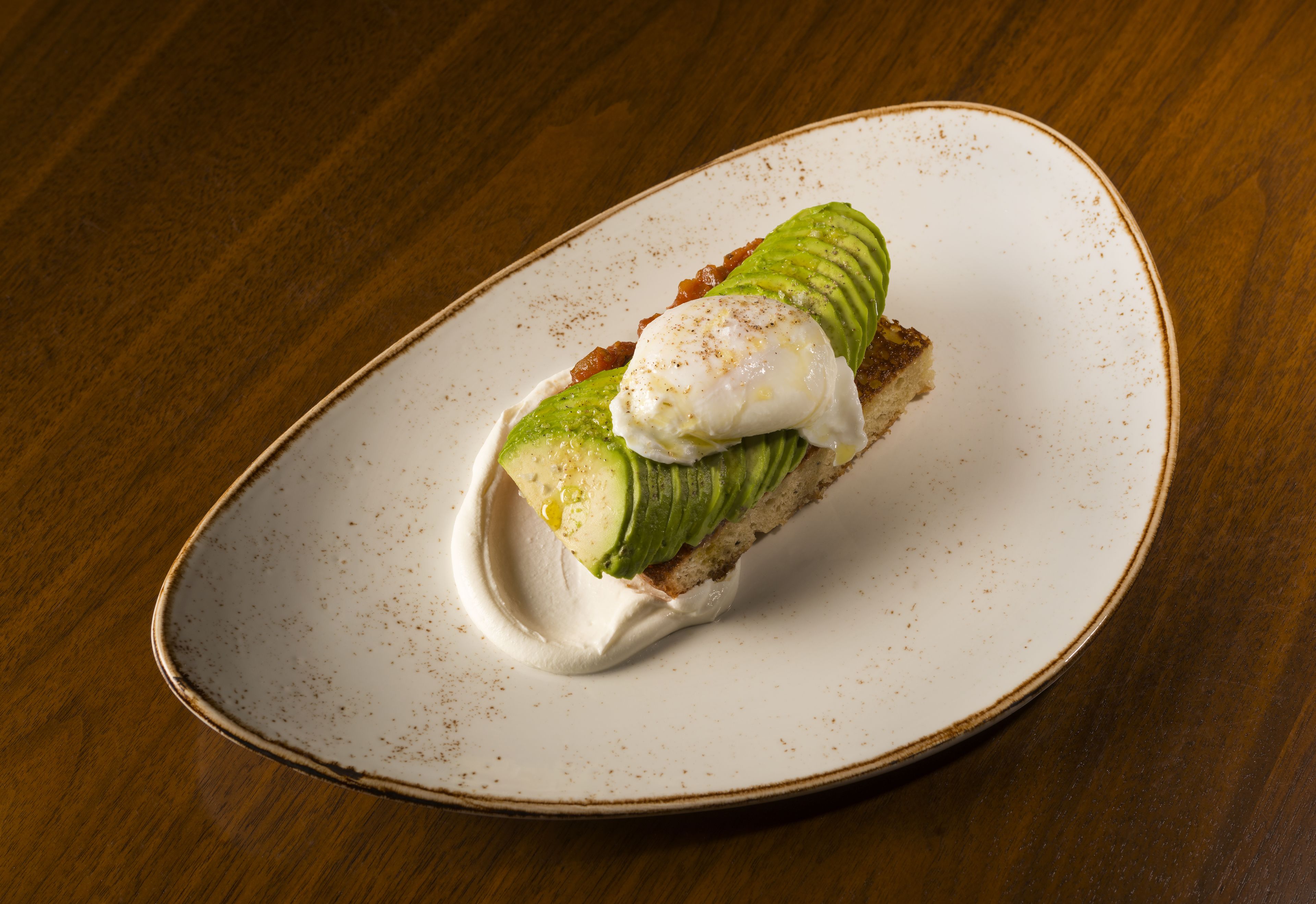 A plate with a sandwich on a wooden table.