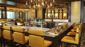 A bar area with a marble countertop, multiple bottles, and a variety of seating options. - del Lago Resort & Casino (Waterloo)