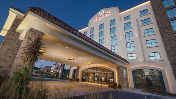 A modern hotel with a prominent entrance, multiple windows, and a well-lit facade. - del Lago Resort & Casino (Waterloo)