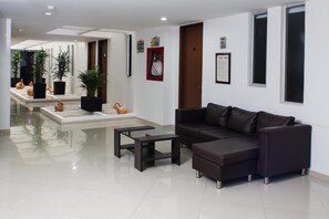 Relax in a contemporary living space with a sleek sofa, coffee table, and potted plants.