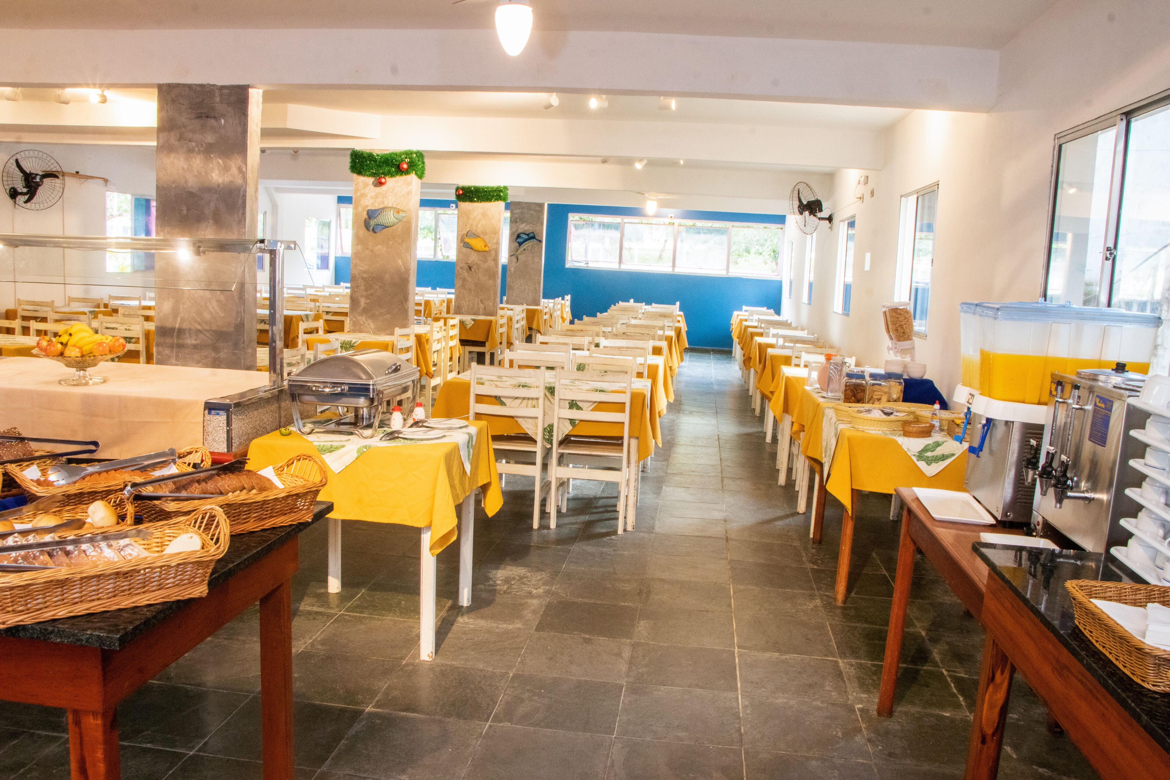 Eine Mensa mit Tischen, Stühlen, Speisenausgabe und einem Buffet.