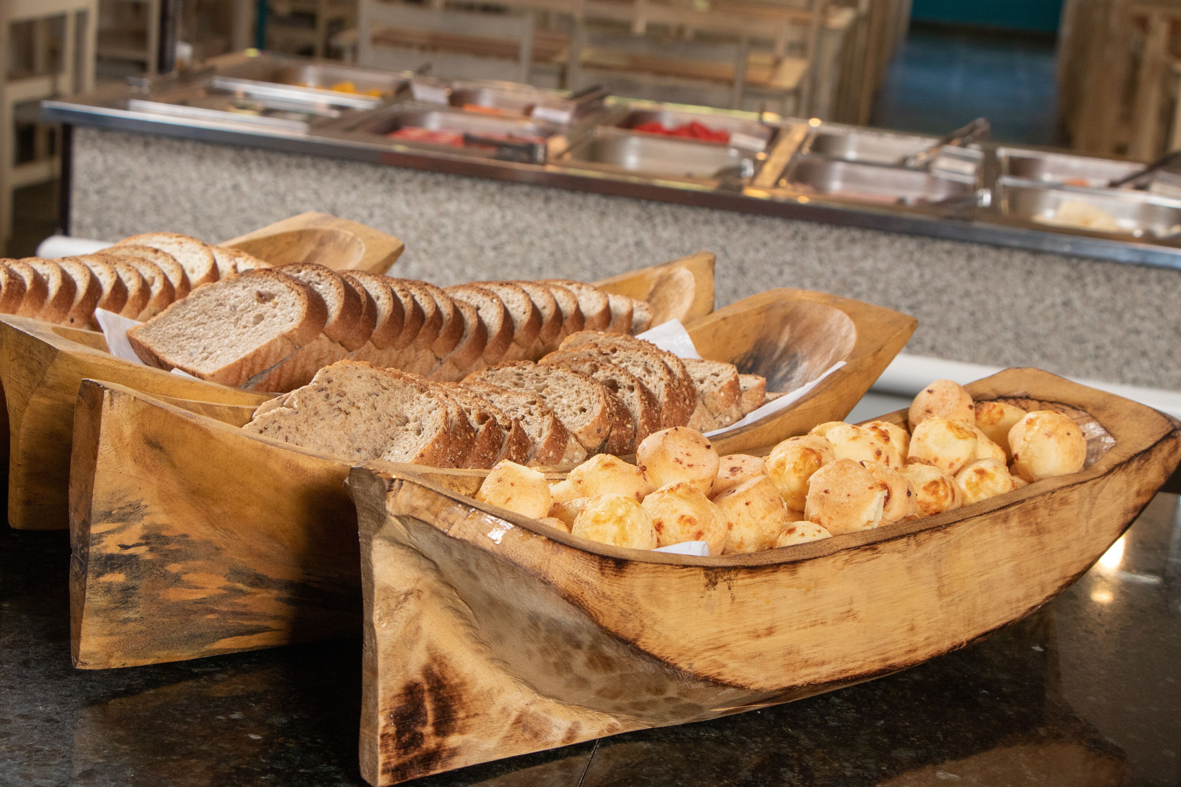 A buffet with various breads and pastries.