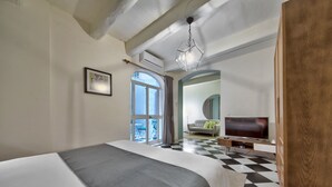 A hotel room with a large bed, a television, and a checkered floor.