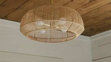 Una stanza con soffitto in legno e lampadario pendente in vimini.