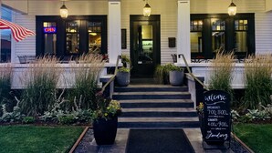 A building with the number 1501, a 'OPEN' sign, and a welcome sign with breakfast and dinner times. - The Landing Hotel and Dining (La Grande)