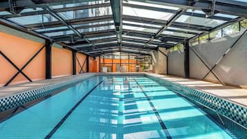 Swimmers can enjoy a clear view of the pool's blue tiled floor from the glass ceiling.