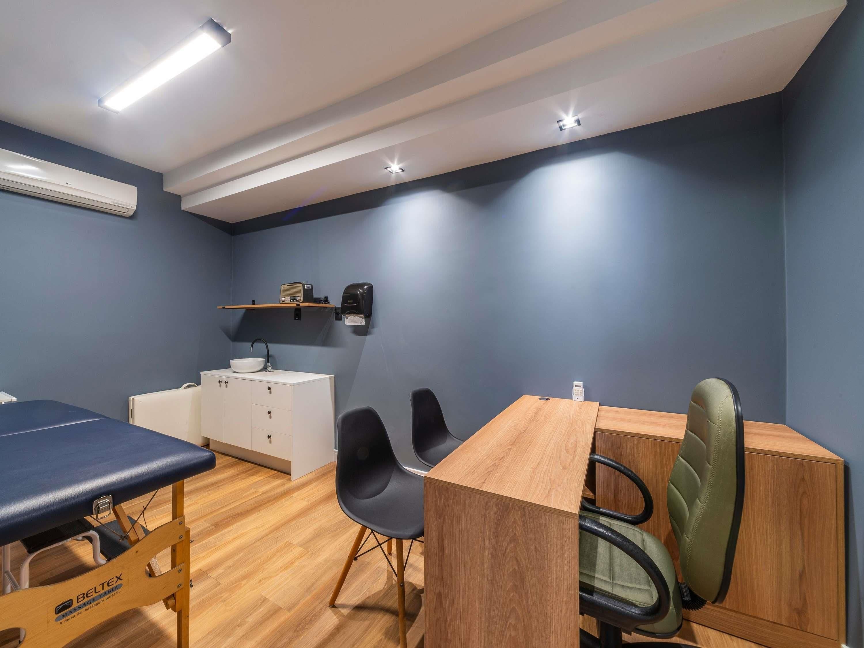 Ein Zimmer mit einem Holztisch, schwarzen Stühlen, einem weißen Schrank und einer blauen Wand.