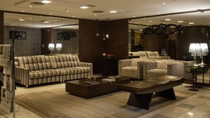 Uma sala de estar moderna com sofás listrados, uma mesa de centro e poltronas estampadas.