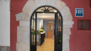 Una entrada con un arco de piedra, un mostrador de recepción y un letrero que indica la oficina de recursos humanos.