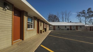 A motel with a covered parking area and a row of rooms. - The Wisconsin Wood Inn (Dickeyville)