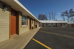 A motel with a covered parking area and a row of rooms. - The Wisconsin Wood Inn (Dickeyville)