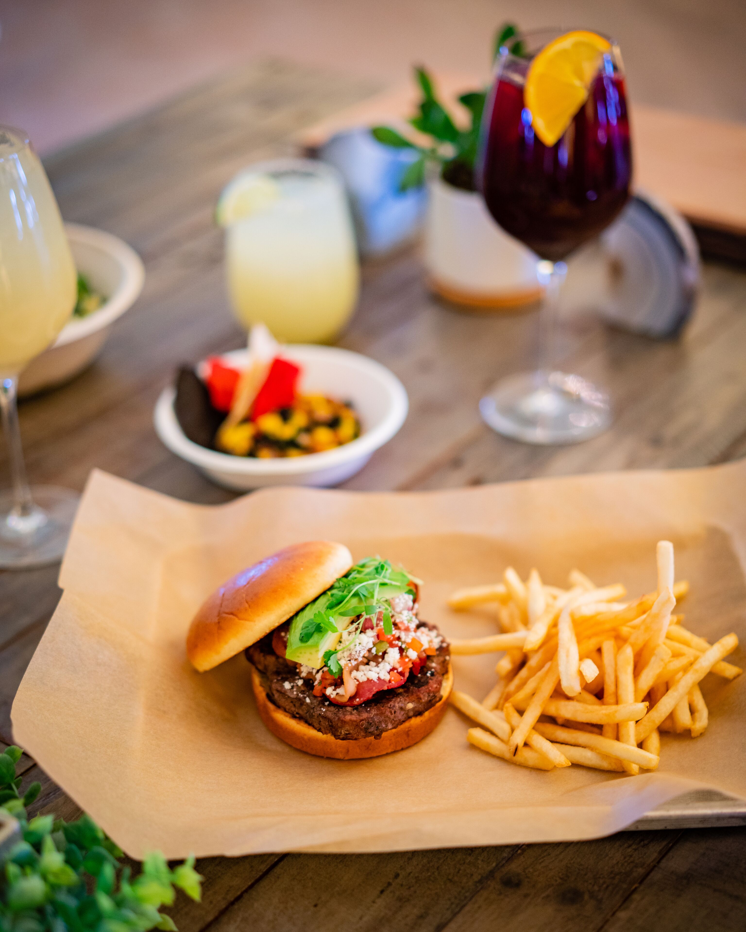 Un hamburger accompagné de frites, servis sur une table en bois.