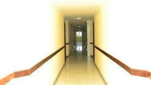 A long, narrow hallway with a shiny tiled floor and wooden handrails on both sides. - Prime Hotel (Feira de Santana)
