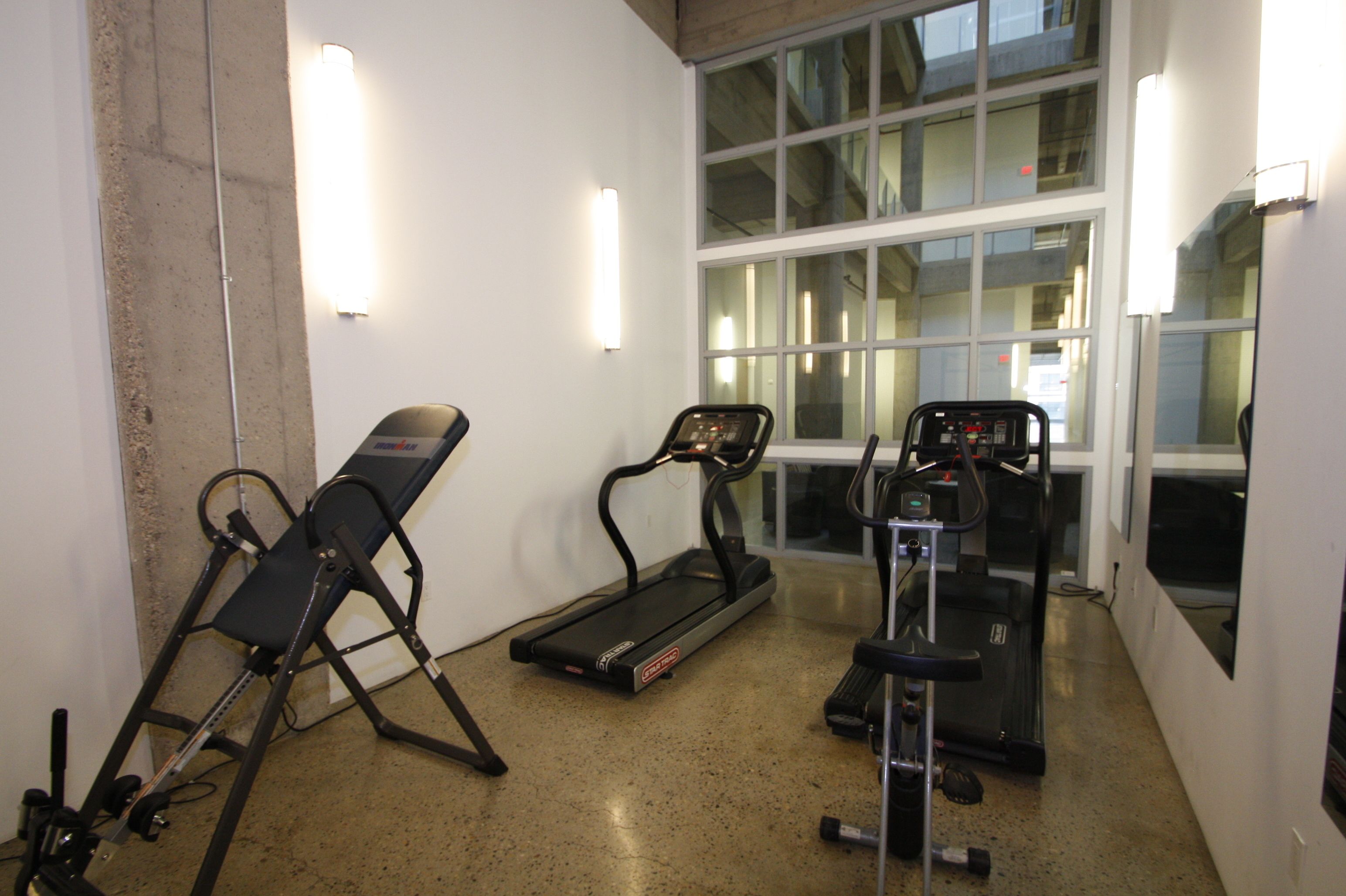 A fitness room with a treadmill, elliptical, and stationary bike.