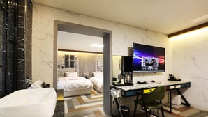 A modern hotel room with a marble bathroom, a large bed, a desk with a chair, and a TV mounted on the wall. - Hotel Mondavi (Mokpo)