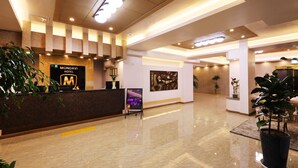 A hotel reception area with a marble floor, a reception desk, and a sign for 'Mondavi Hotel'. - Hotel Mondavi (Mokpo)