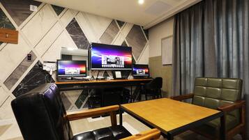 A modern room with a wooden table and chairs, a large flat-screen TV, and a green leather chair.