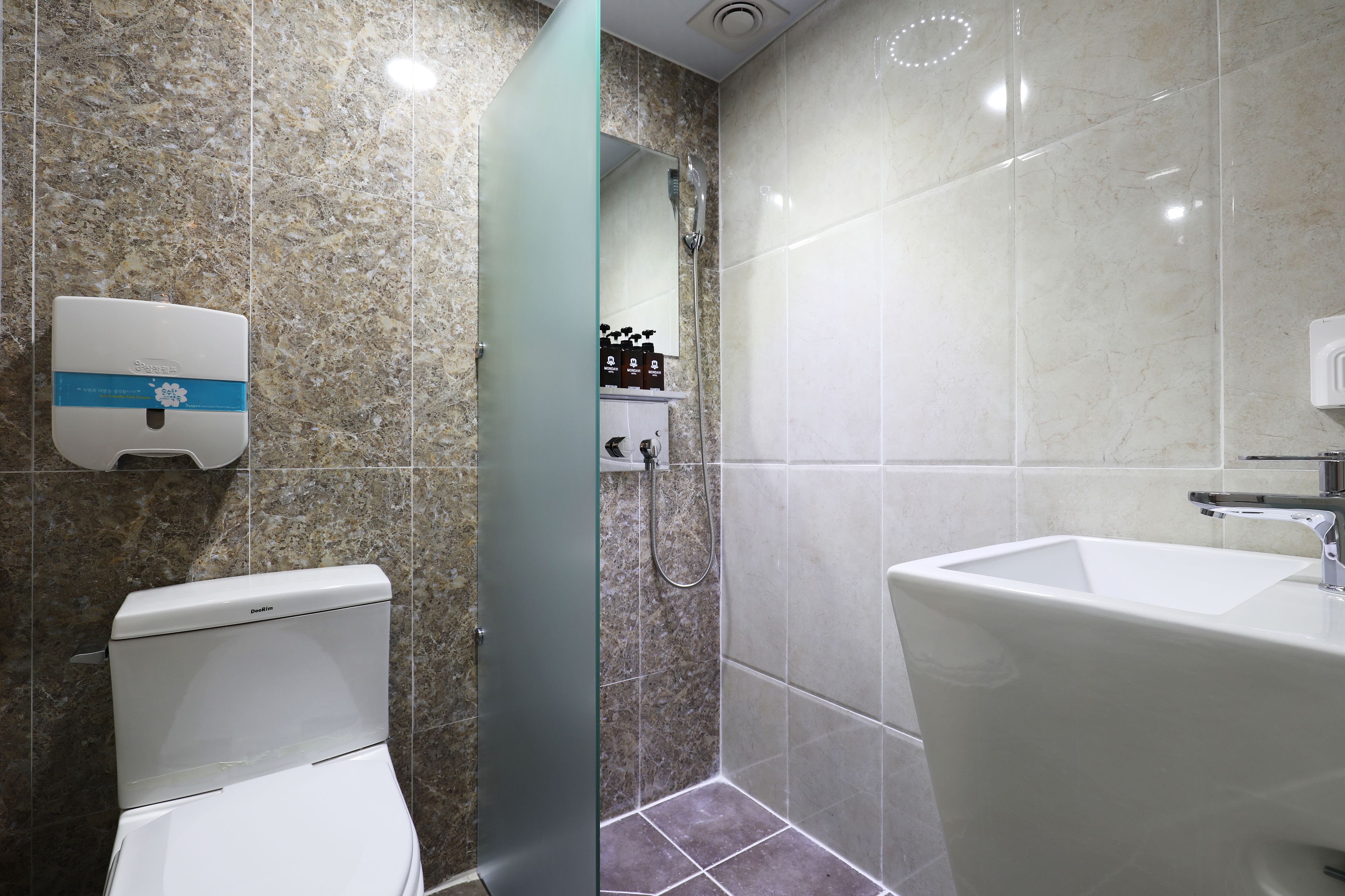 A bathroom with a toilet, a sink, and a shower.