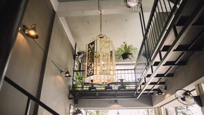 A staircase with a metal railing, a hanging light fixture, and a potted plant. - The Beach Cha Am Suite (Cha-am)