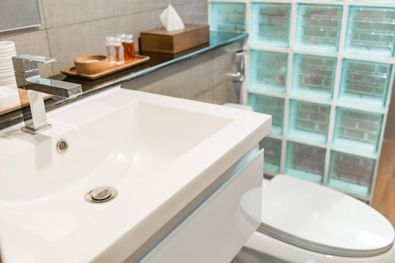 Un baño moderno con un lavabo blanco, cabina de ducha con mampara de vidrio y un inodoro.