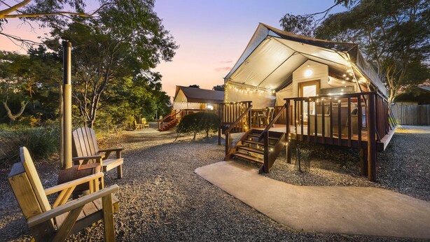 A cozy, tent-like structure with a wooden deck and stairs leading to a covered entrance. - Scamander Sanctuary Holiday Park (Scamander)