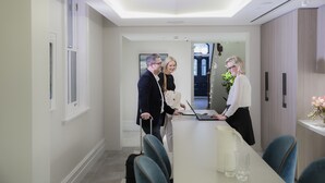 A modern interior with a long table, chairs, and a person using a laptop. - Spicers Potts Point (Potts Point)