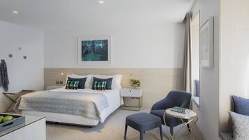Une chambre d’hôtel moderne avec un grand lit, un bureau, une chaise et une petite table.
