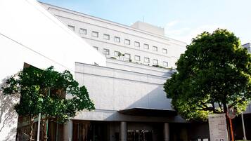 Un edificio moderno con fachada plana, ventanas amplias y entrada protegida por una reja.