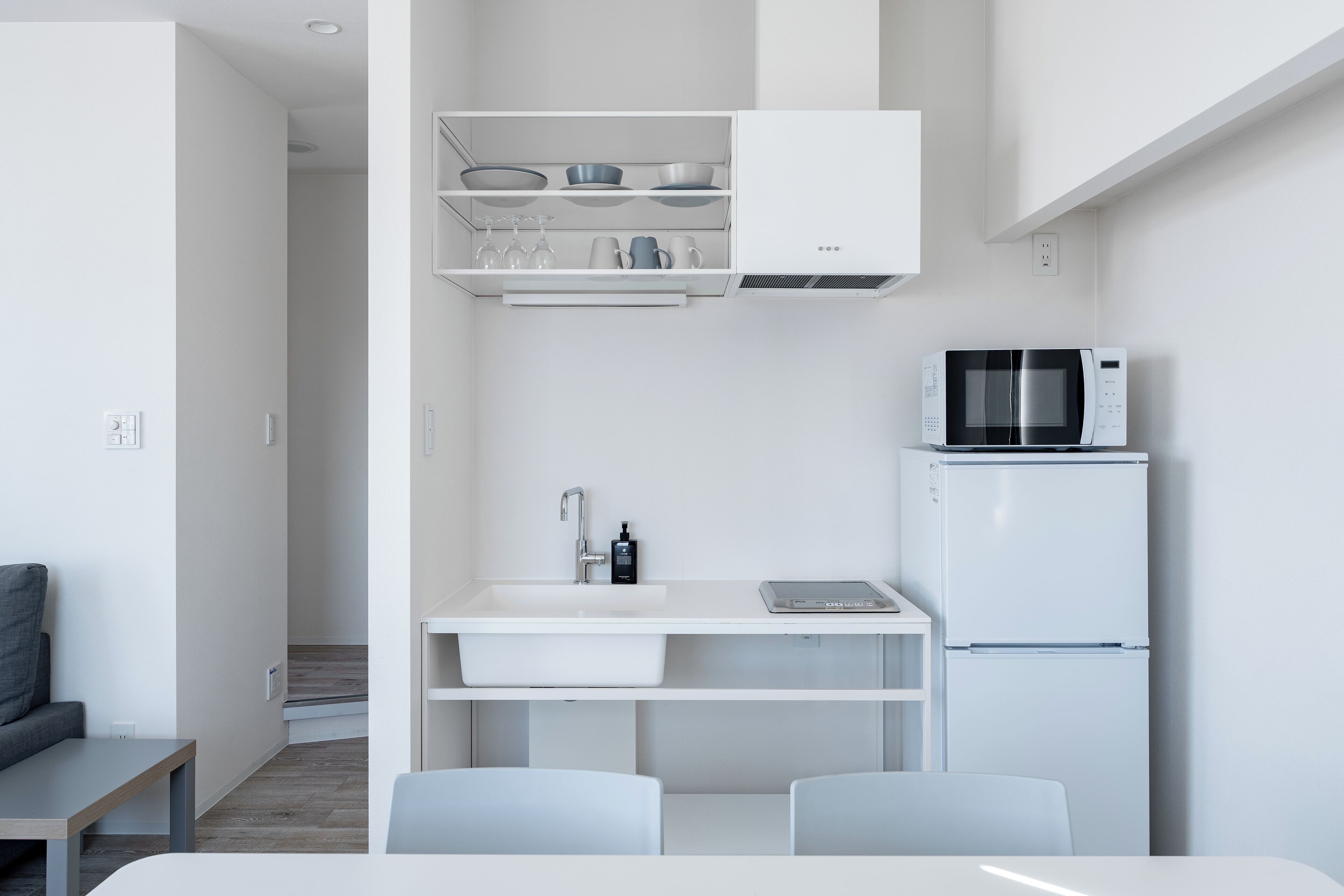 A modern kitchen with white cabinetry, a built-in microwave, and a sink.