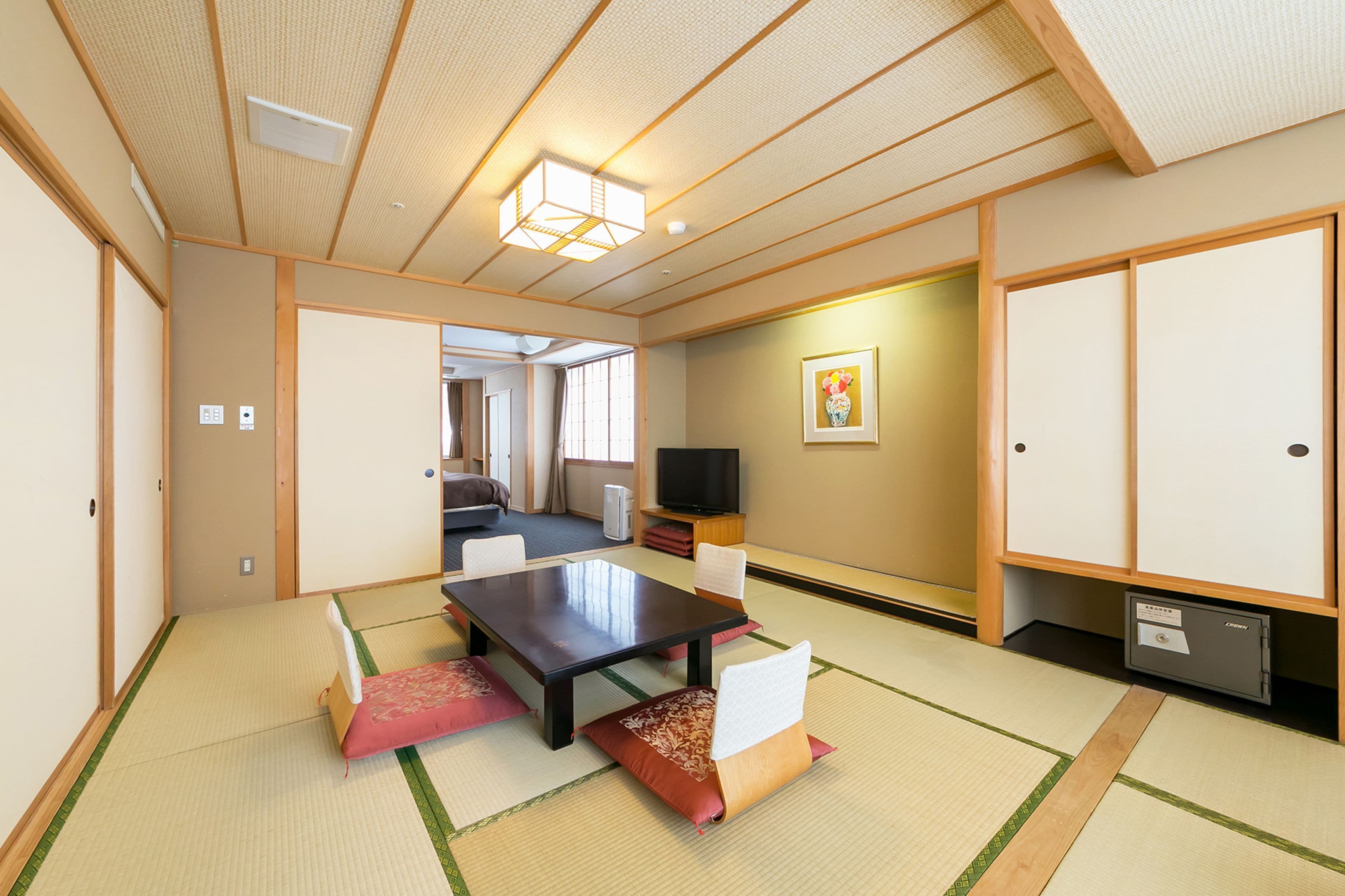 Una habitación japonesa tradicional con suelo de tatami, una mesa baja y un televisor.