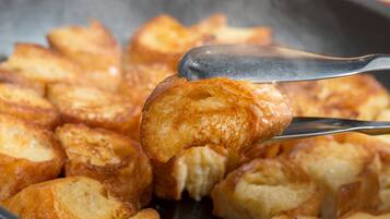 A close-up of golden-brown toast being lifted with tongs.