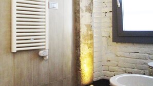 A bathroom with a bathtub, a window, and a radiator. - 15 Quindici by Serendipity Rooms (Milan)