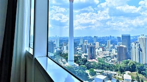 A high-rise building with a distinctive tower, surrounded by other skyscrapers and greenery. - Saba Suites at Vortex KLCC Bukit Bintang (Kuala Lumpur)
