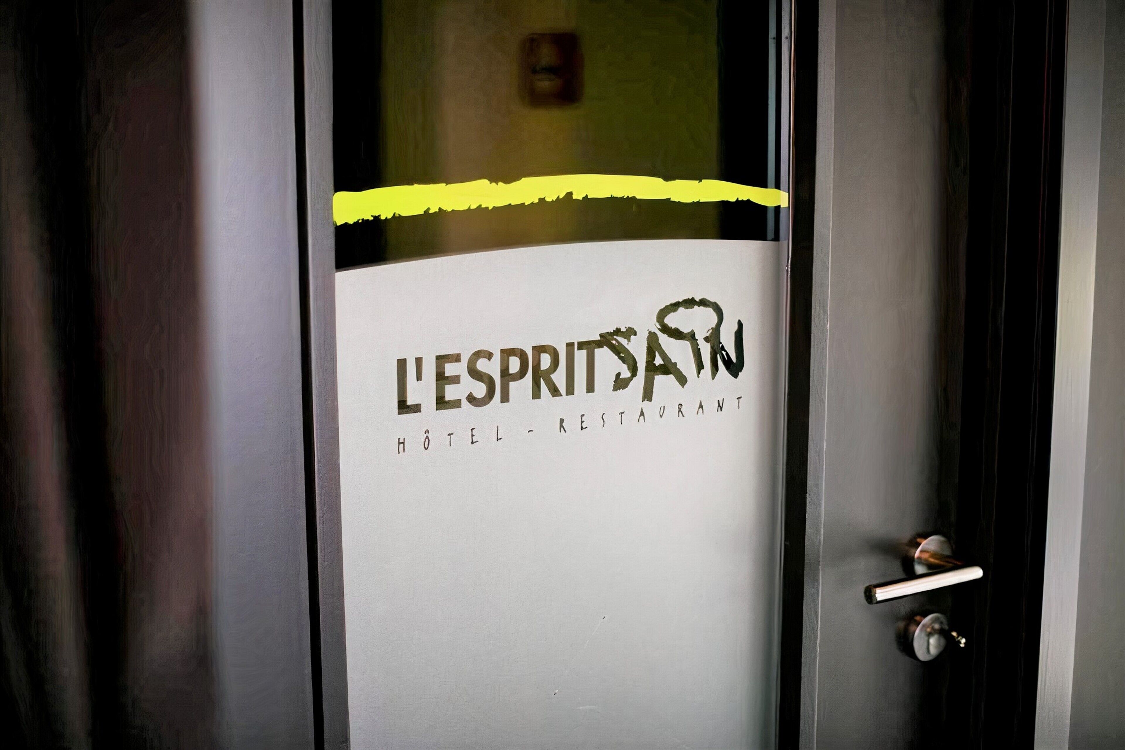 Una puerta de hotel con un cartel que dice 'L'ESPRIT SAW HOTEL RESTAURANT'.