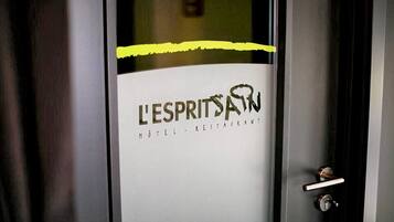 Una puerta de hotel con un cartel que dice 'L'ESPRIT SAW HOTEL RESTAURANT'.
