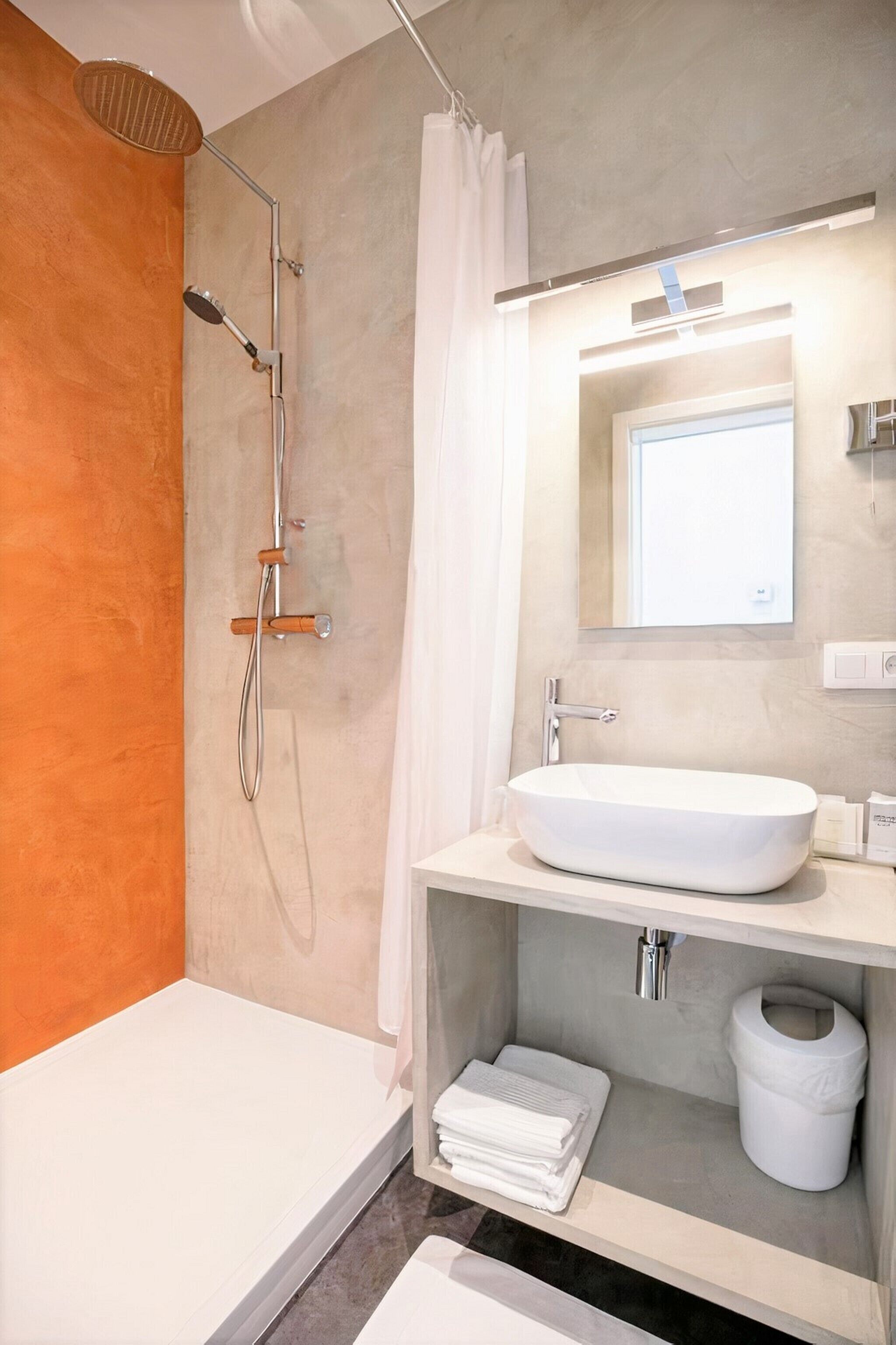 Een moderne badkamer met een bad, douche, wastafel en toilet.