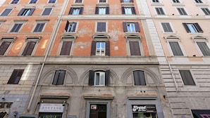 Un edificio de varios pisos con una mezcla de estilos arquitectónicos, incluyendo arcos y una entrada destacada.