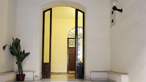 Una escalera que lleva a una habitación con una pared amarilla y una puerta con un diseño decorativo.