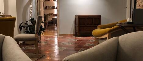 Una sala de estar con chimenea, un sillón amarillo y un sofá.