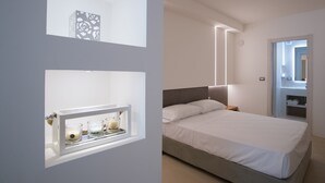 A modern bedroom with a bed, bedside table, and a mirror.