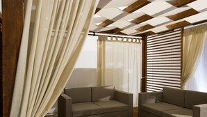 A modern living room with two sofas, a glass coffee table, and a wooden ceiling.