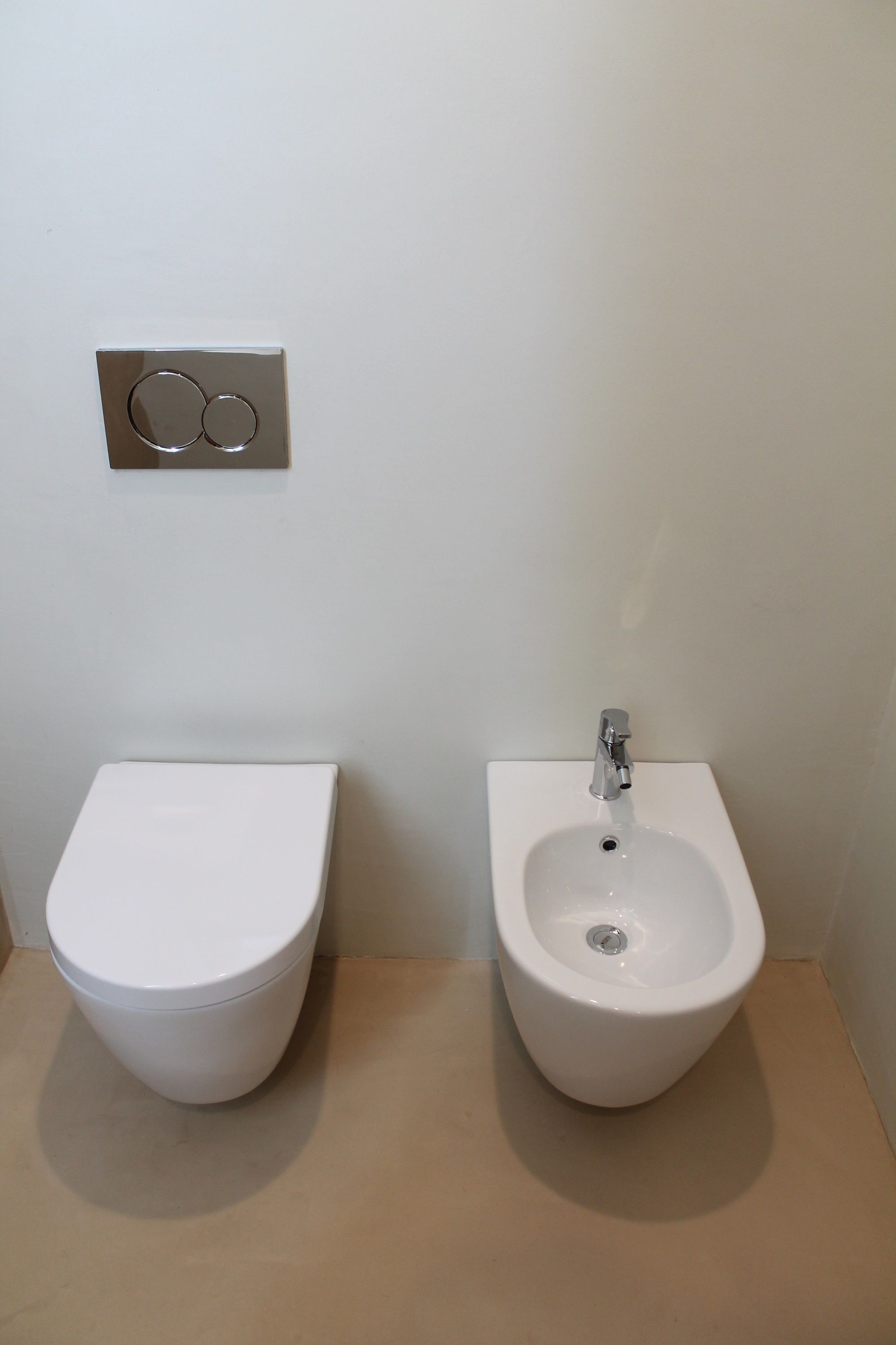 A bathroom with a toilet and bidet.