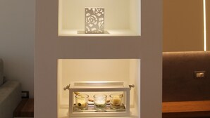 A wall with three shelves containing decorative items.