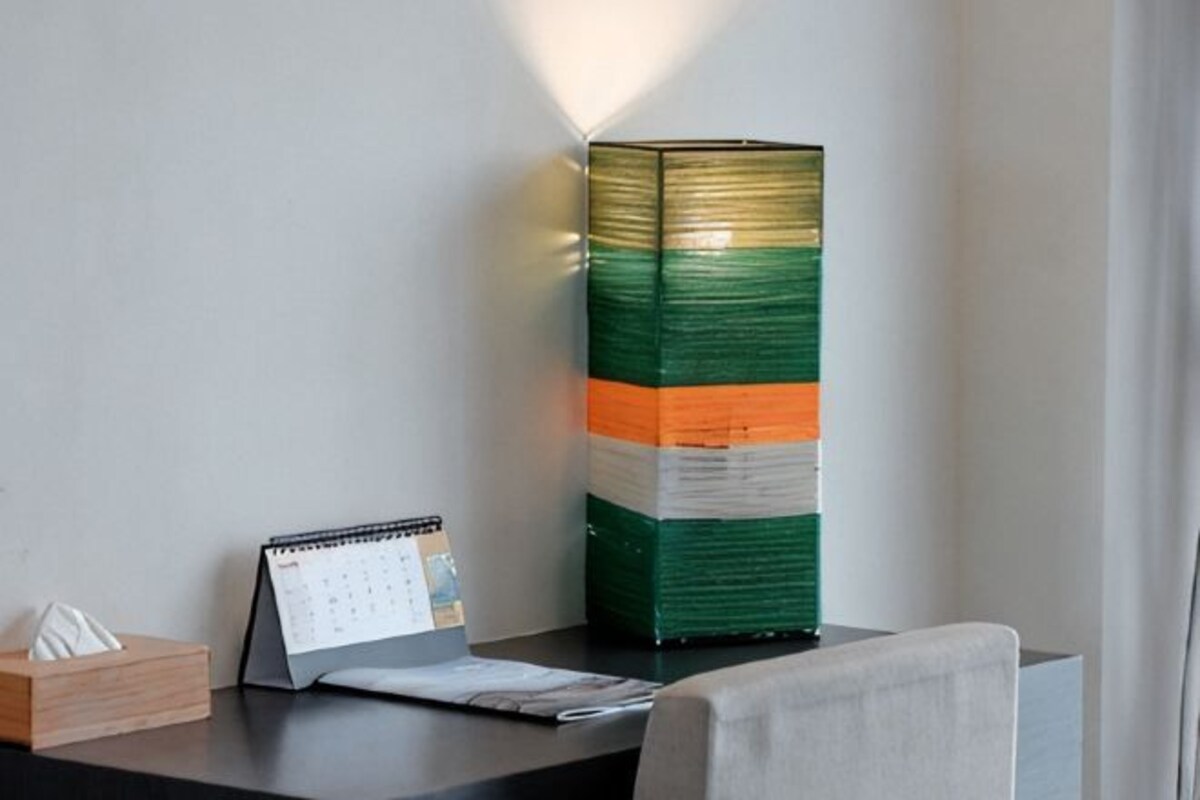 A desk with a calendar, a lamp, and a box of tissues.