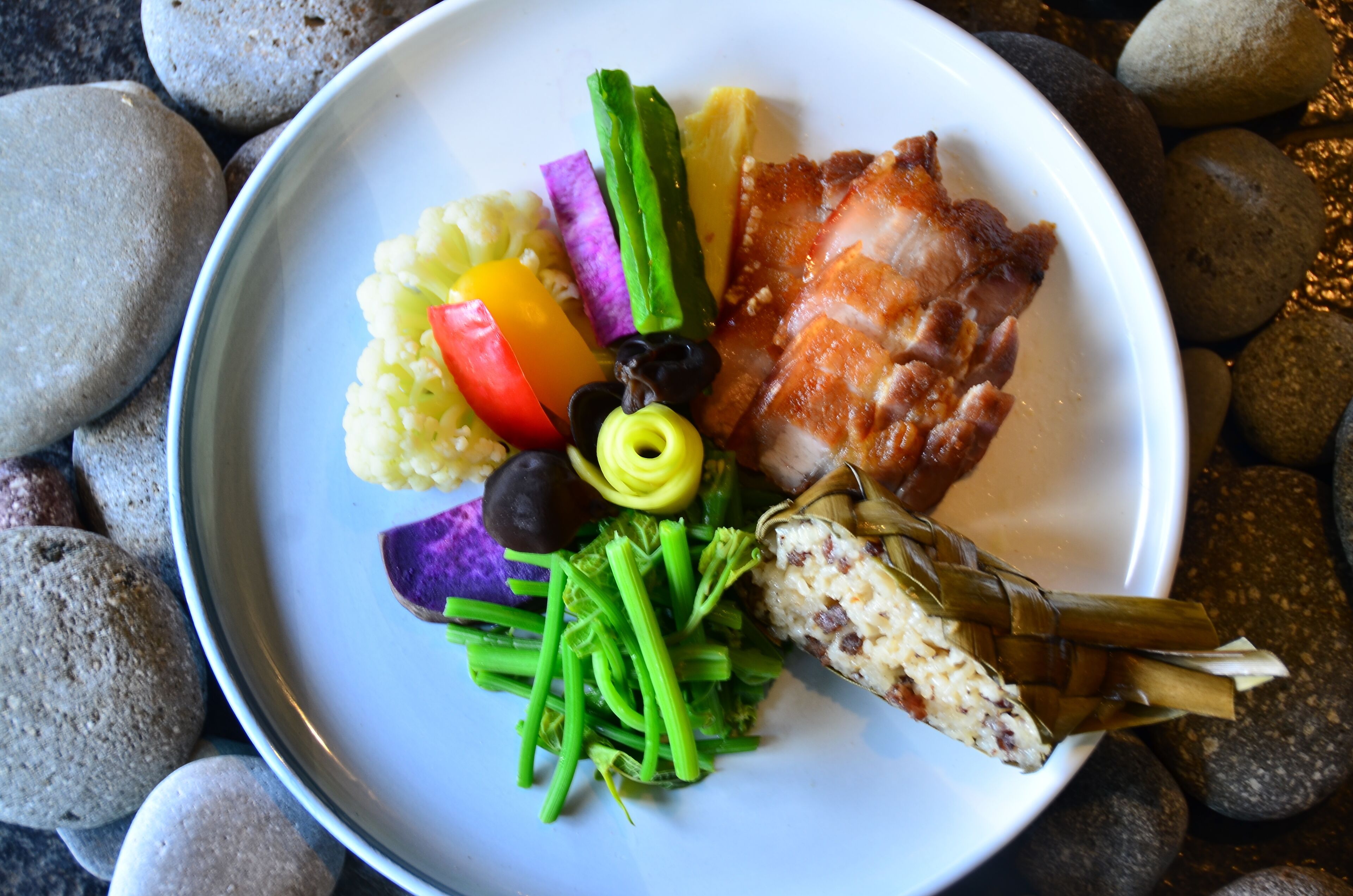 A plate with various foods including rice, vegetables, and meat.