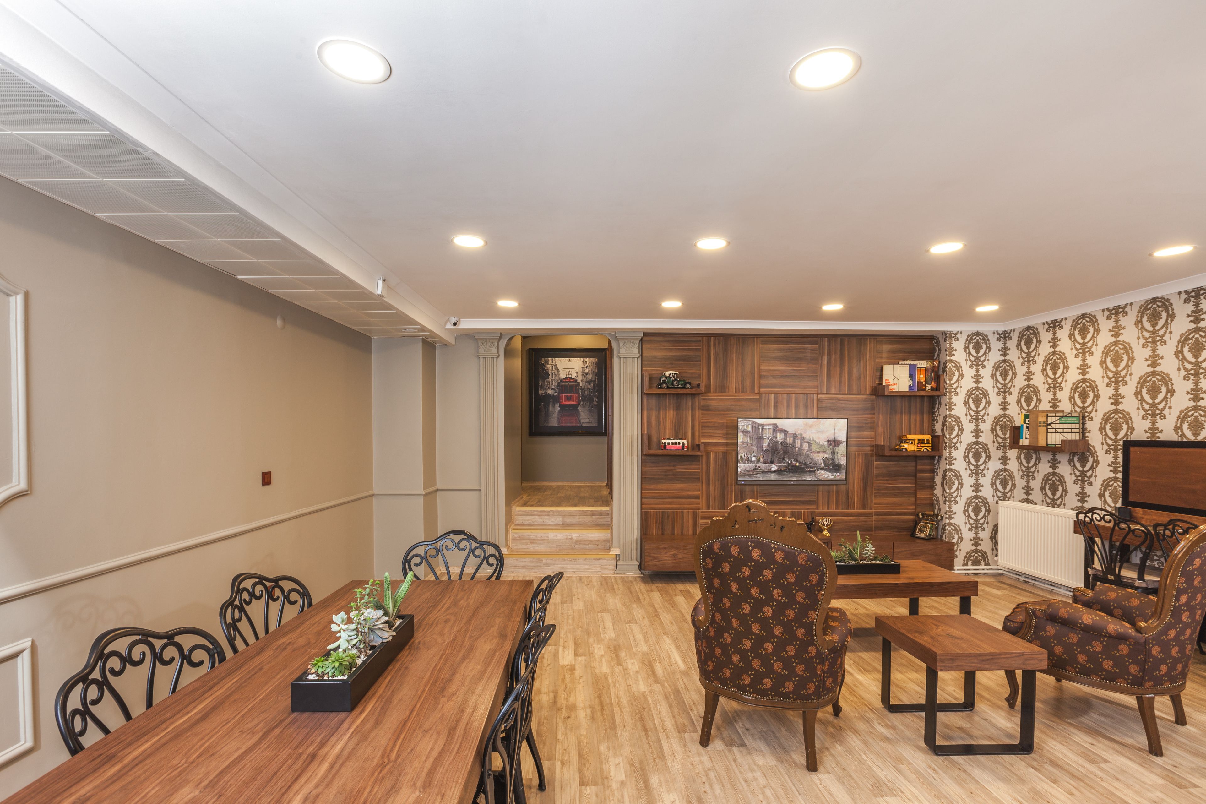 A dining area with a wooden table and chairs, a coffee table, and a sofa.