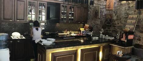 Una cocina con una isla grande, armarios de madera y una pared de piedra.