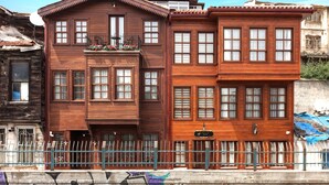 Un edificio de madera de dos pisos con varias ventanas y un balcón adornado con flores.