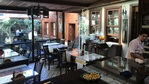 Un restaurante con terraza, mesas y sillas de madera.